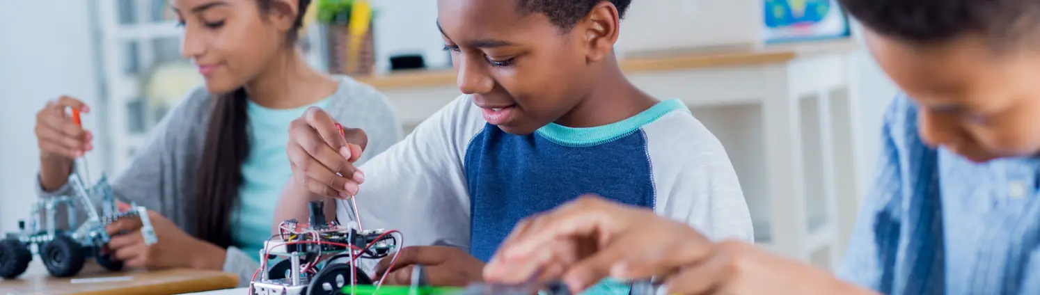 Drei Schülerinnen und Schüler experimentieren in der Energie-Werkstatt der Schülerakademie Elbe-Elster.