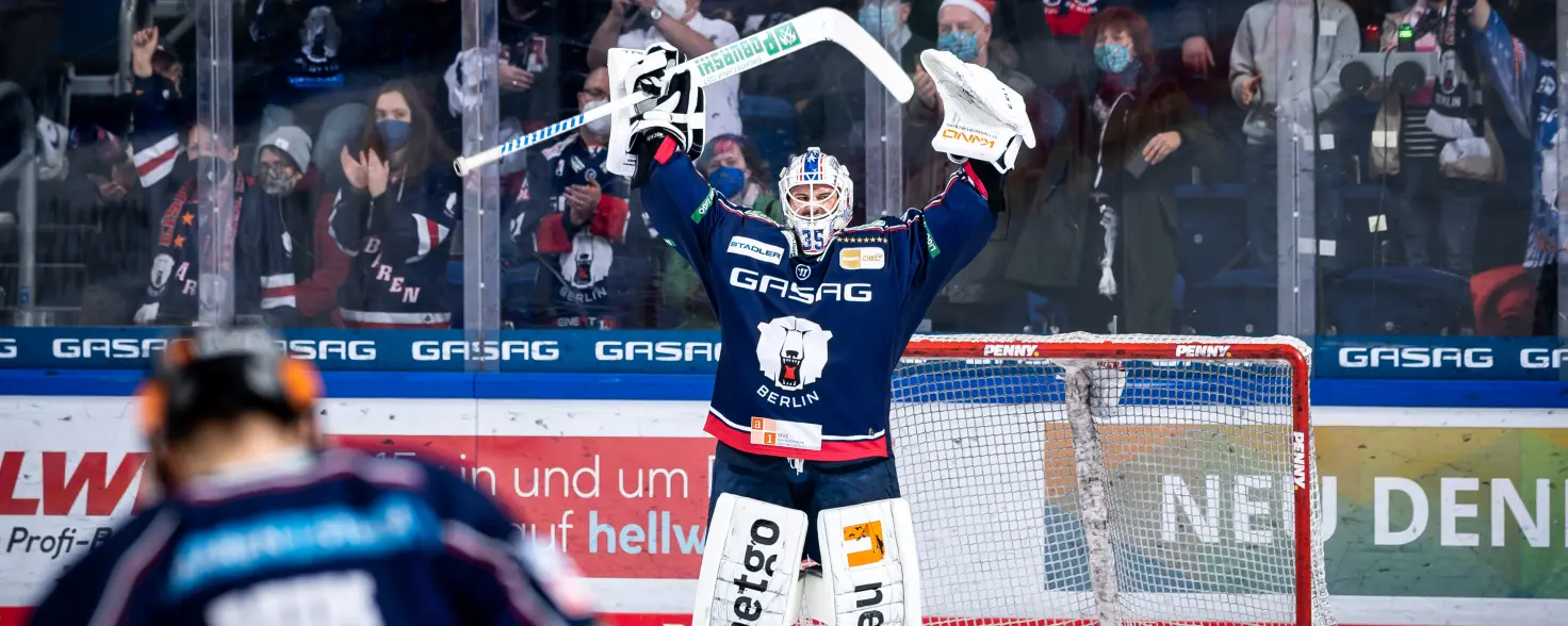 Torwart der Eisbären Berlin reckt den Eishockey-Schläger über den Kopf.