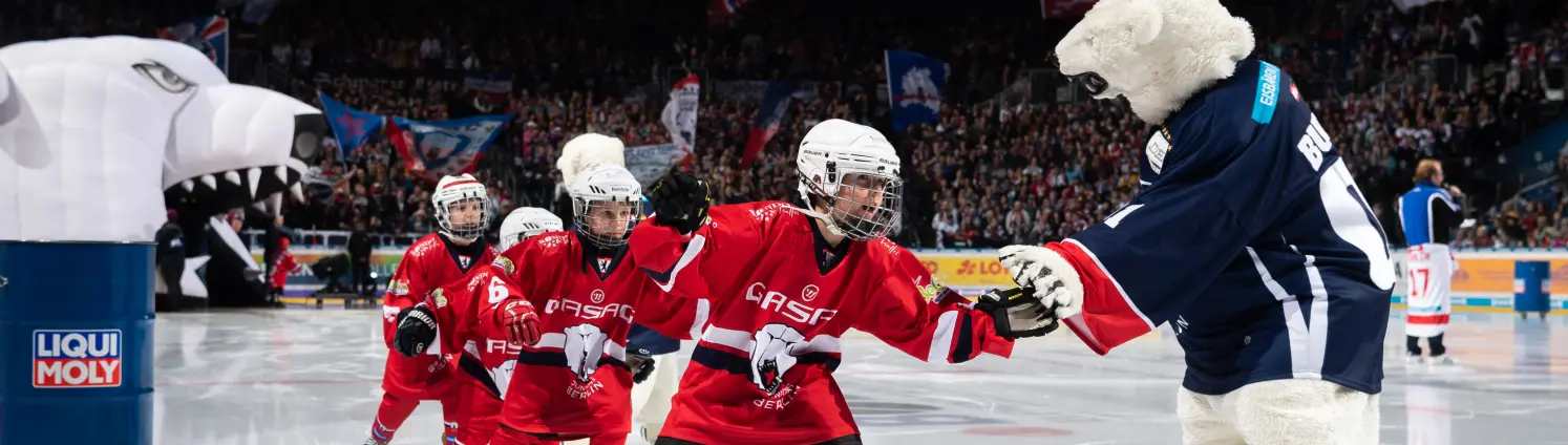 Handschlag der Eisbären Juniors mit dem Maskottchen Bully.