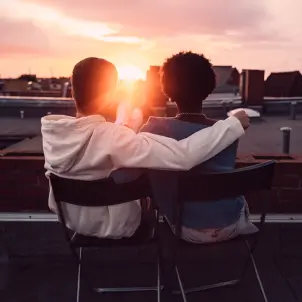 Zwei Personen schauen sich gemeinsam den Sonnenaufgang an