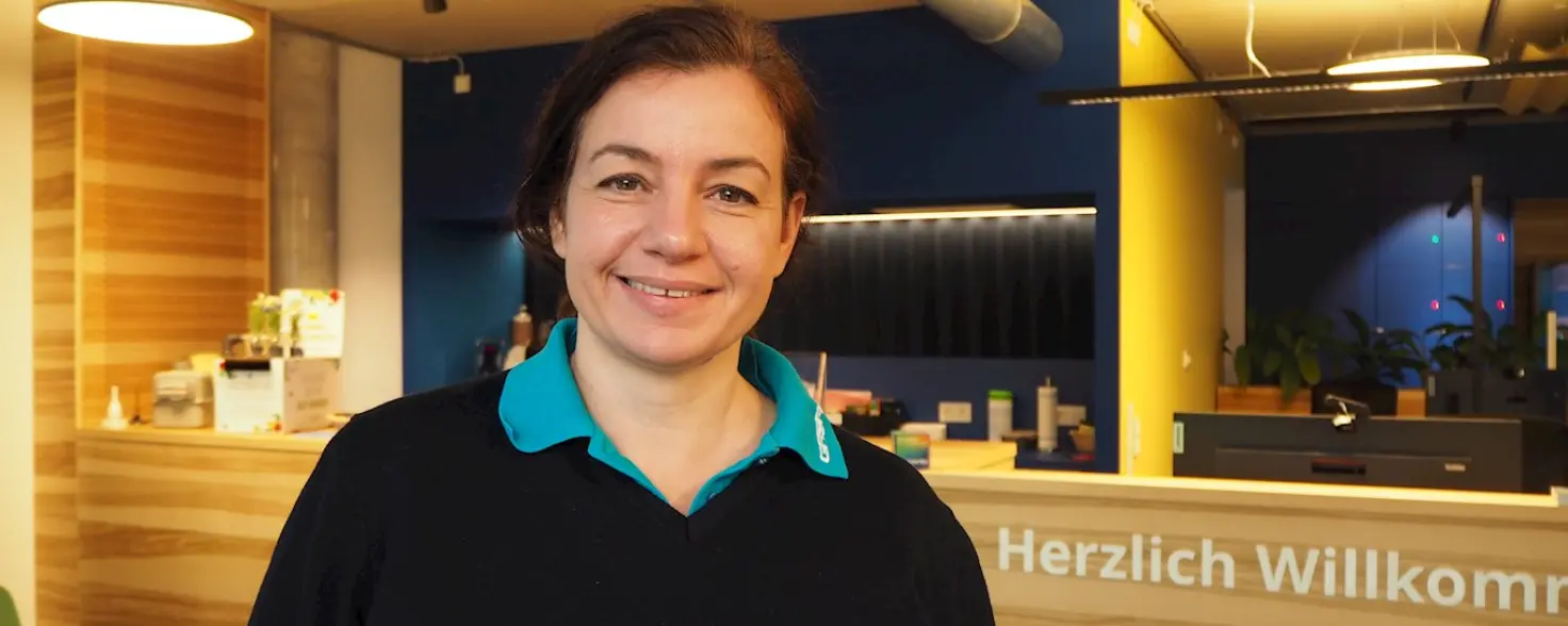 Dana Fritz steht im hell beleuchteten GASAG-Kundenzentrum und lächelt in die Kamera