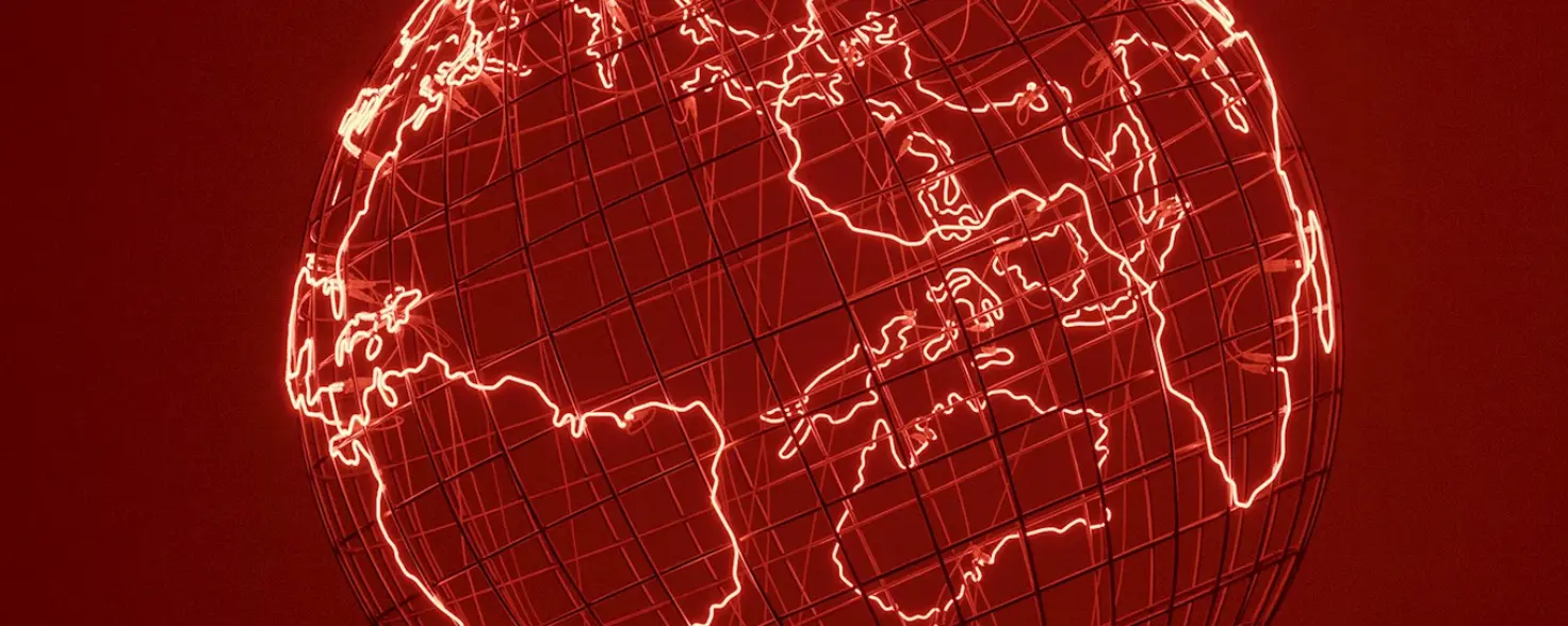 Ein Globus aus Metallstreben, die Kontinente rot leuchtend umrandet. Der Boden reflektiert das rote Licht.