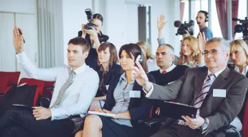 Pressemitteilungen: Medienvertreterinnen und Medienvertreter stellen Fragen bei einer Pressekonferenz.