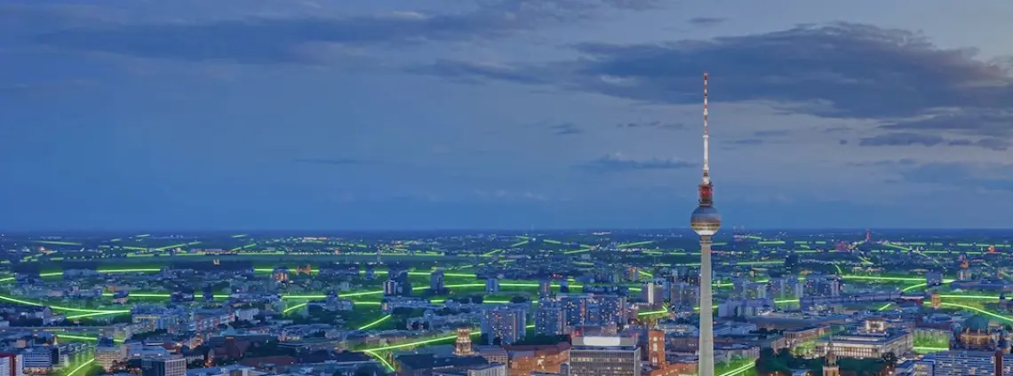 Berlin aus der Vogelperspektive bei Nacht mit Fernsehturm im Bild-Zentrum und grünen Linien, die die Straßen nachzeichnen
